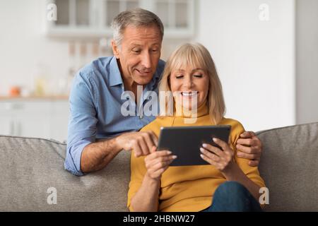 Senior Husband And Wife Using Digital Tablet Together At Home Stock Photo