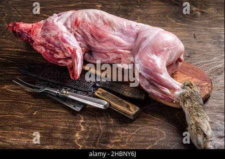 Whole game hare, raw meat on wooden old rustic table. Wooden background. Top view Stock Photo