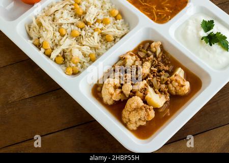 Traditional Turkish rice made with chickpeas and chicken and cooked cauliflower with mince in tray table d'hote on wooden table Stock Photo