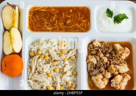 Traditional Turkish rice made with chickpeas and chicken and cooked cauliflower with mince in tray table d'hote on wooden table Stock Photo