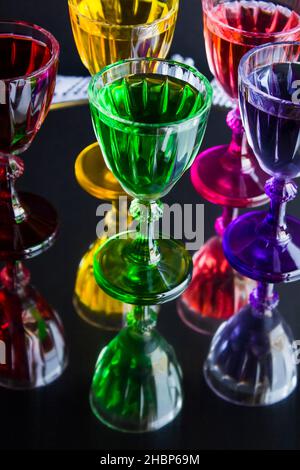 Colorful and stylish glasses of liqueur,on the mirror tray,vertical image Stock Photo