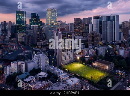 Tokyo, Japan - October 23, 2019: Night view of Athletic Field at Shiba koen public park in front of Holland Hills Mori tower at skyscrapers center of Stock Photo