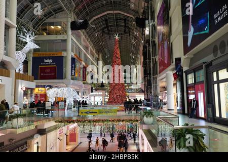 Toronto's Eaton Center is a multi-level indoor mall, with bright Christmas decorations and shoppers wearing face masks due to the pandemic Stock Photo