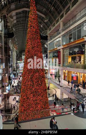 Toronto's Eaton Center is a multi-level indoor mall, with bright Christmas decorations and shoppers wearing face masks due to the pandemic Stock Photo