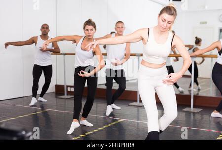 Concentrated women and men rehearsing ballet dance Stock Photo - Alamy
