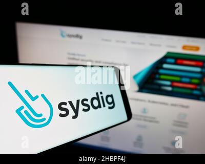 Smartphone with logo of American cloud security company Sysdig Inc. on screen in front of business website. Focus on left of phone display. Stock Photo