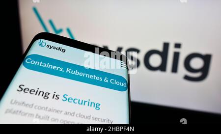 Mobile phone with website of American cloud security company Sysdig Inc. on screen in front of business logo. Focus on top-left of phone display. Stock Photo