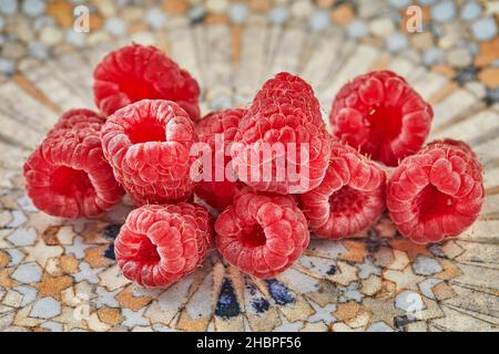 Fresh raspberries lying on plate for eating Stock Photo