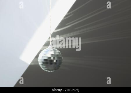 Silver disco ball reflects sunlight on silver background. Motion blur. Stock Photo