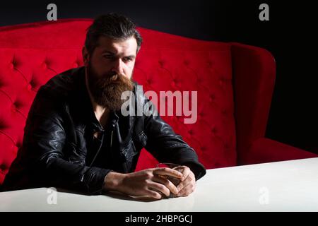 Elegant and stylish man in classical wear with wiskey. Cheerful bearded sman is drinking expensive whisky. Old traditional whiskey drink - gentlemans Stock Photo