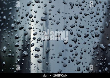 The deep water droplets on the black surface and some of the water droplets are blurry Stock Photo