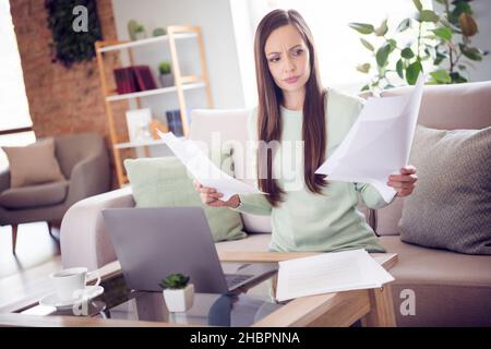 Photo of work young brunette lady sit on sofa look paper wear blue shirt at home alone Stock Photo
