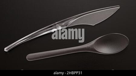 Plastic knife and spoon on black background Stock Photo