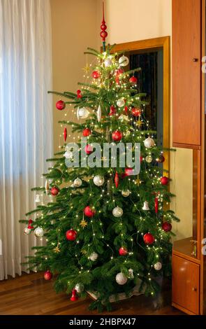 Weihnachten, festlich dekorierter und geschmueckter Weihnachtsbaum in einem Wohnzimmer, Christbaumkugeln, Weihnachtssterne, Deutschland, Oberhausen, O Stock Photo