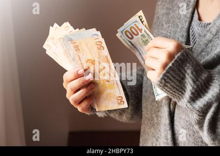 Turkish lira and dollar banknotes in woman hands. The paper currency of Turkey. Current Turkish liras are issued by The Central Bank of the Republic of Turkey. Financial crisis concept. Stock Photo
