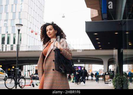 Businesswoman walking on street while going to work Stock Photo