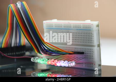 Breadboard with glowing lights from LED with reflections on the glass Stock Photo