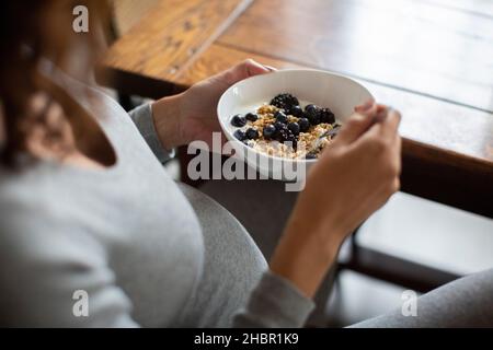 Midsection of woman having oats during breakfast at home Stock Photo