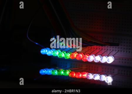 Glowing Light emitting diodes with reflections on the glass, LED bulbs displaying colorful lights Stock Photo