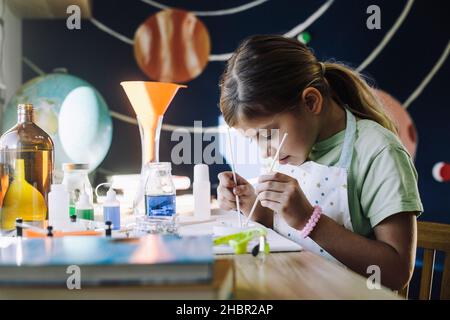 Ambitious female student learning scientific experiment at home Stock Photo