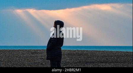Brighton UK 21st December  2021 - The sun breaks through the clouds along Brighton seafront on a cold morning as more mild wet weather is forecast for the Christmas weekend  : Credit Simon Dack / Alamy Live News