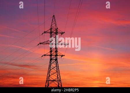 Incredibly colorful fiery red sunset. View of power lines and wires at sunset Stock Photo
