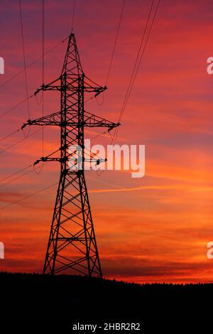 Incredibly colorful fiery red sunset. View of power lines and wires at sunset Stock Photo