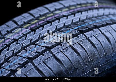Frosted car tires close-up wheel profile structure on black background. Stock Photo