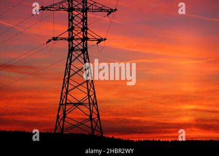 Incredibly colorful fiery red sunset. View of power lines and wires at sunset Stock Photo