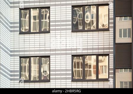 laminated plastic windows on the facade of apartment buildings Stock Photo
