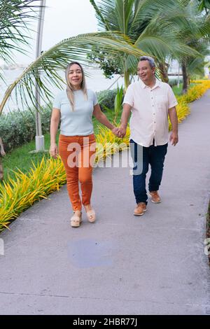 Older couple having fun in the park. The focus is on the woman. Copy space. Stock Photo