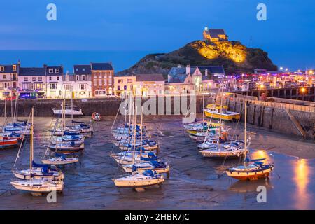 The illuminated Chapel of St Nicholas above the fishing boats and yachts in the harbour and town of Ilfracombe Devon England UK GB Europe at night Stock Photo