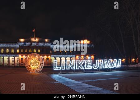 Vilnius, Lithuania - December 17th, 2021: illuminated word Greetings in Lithuanian - Linkejimai - near Presidential Palace Stock Photo