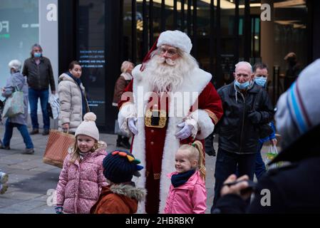 Newcastle, UK. 21st December, 2021. Busy crowds shopping on Northumberland Street in Newcastle as a Santa Claus entertains them, UK. Credit: Garry Cook/Alamy Live News. Stock Photo