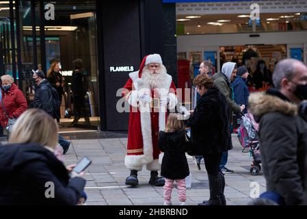 Newcastle, UK. 21st December, 2021. Busy crowds shopping on Northumberland Street as a Santa Claus enteratains them in, UK. Credit: Garry Cook/Alamy Live News. Stock Photo