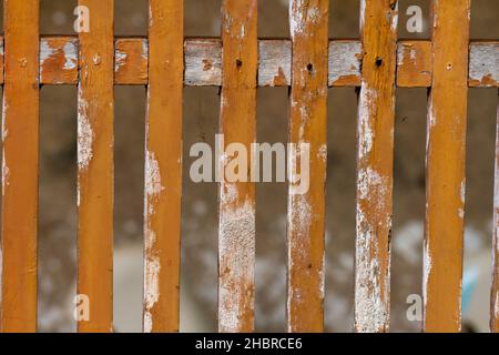 The brown wooden fence that has faded and is mossy, looks old and aged Stock Photo