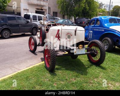 LOMAS DE ZAMORA - BUENOS AIRES, ARGENTINA - Dec 05, 2021: Sporty vintage Overland 1919 speedster baquet for racing. Rear left view. Sinclair gasoline Stock Photo