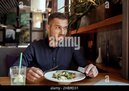Young businessman is having lunch in restaurant Stock Photo