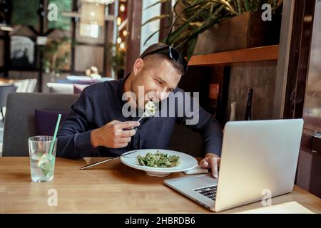 businessman is having lunch while talking on phone in restaurant. remote work. Stock Photo