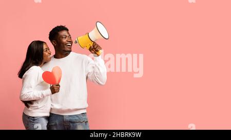 Beautiful black couple with red heart making announcement Stock Photo