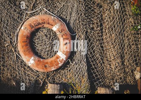 A closeup shot of fishing tools. A red lifebuoy and rope Stock Photo