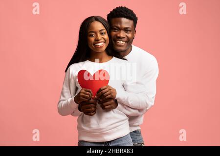Emotional african american lovers posing with big red heart Stock Photo