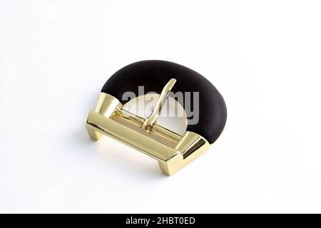 Buckle for a strap on a white background. Metallic gold buckle with matte base. Buckle for bags or clothes. Metal fittings close-up. Stock Photo