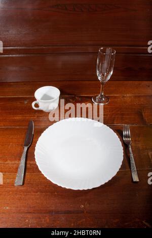 empty plate spoon fork and knife on table Stock Photo