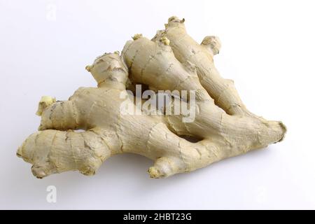 Fresh ginger root on a white plate close-up. A piece of ginger root top view. Stock Photo