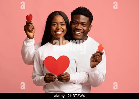 Happy african american lovers posing with red hearts Stock Photo