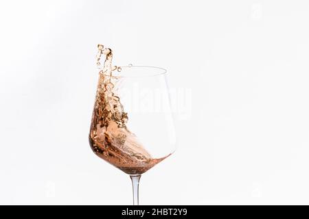 Glass of splashing alcohol on a light background Stock Photo