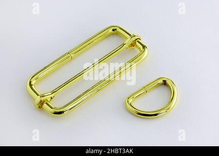 Metal strap adjuster, gold color. Metal half ring for a bag. Regulator with a movable part for changing the length of the strap on the bag. Accessorie Stock Photo