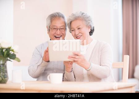 Elderly couple using a tablet computer at home Stock Photo