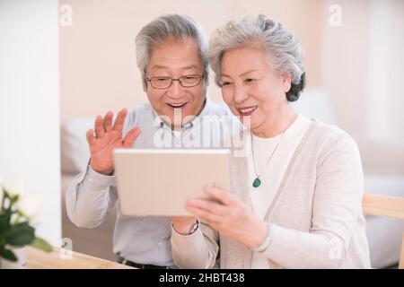 Elderly couple using a tablet computer at home Stock Photo